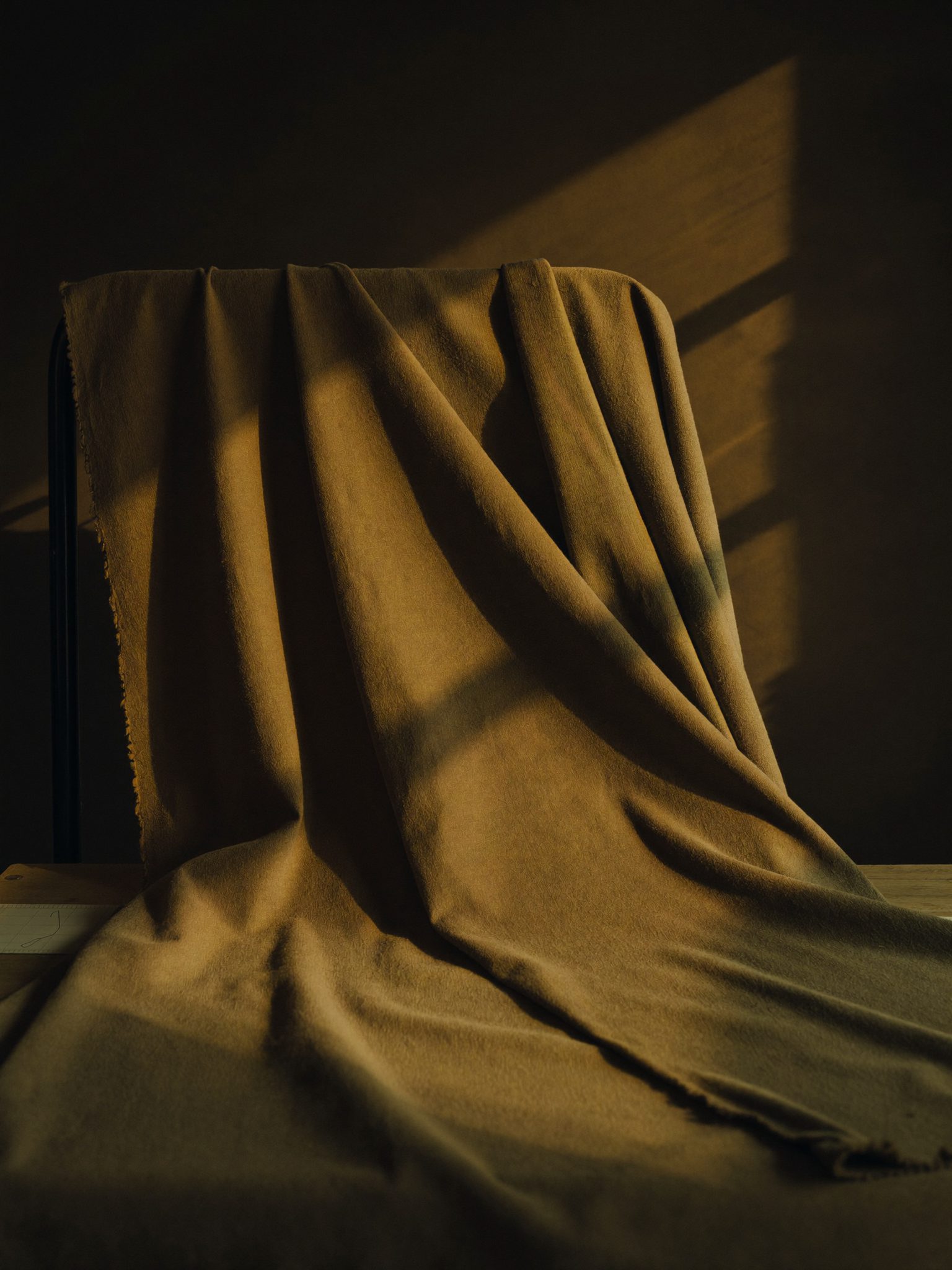 Kain terdrape dengan cahaya keemasan di atelier Puri Dangin Atelier
